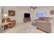 Comfortable living room with stone tile floors, a modern TV, a ceiling fan, and a cozy armchair at 7235 Summer Air Ave, Las Vegas, NV 89179