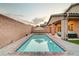 An inviting backyard pool, surrounded by neat brickwork and an umbrella for shade at 7235 Summer Air Ave, Las Vegas, NV 89179