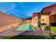 Inviting backyard with a refreshing pool, covered patio, and well-maintained artificial grass area at 7235 Summer Air Ave, Las Vegas, NV 89179