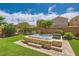 Beautiful backyard features a stone-accented hot tub, lush artificial grass, and mature trees at 7424 Rainford St, Las Vegas, NV 89148