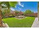 Backyard oasis with a built-in hot tub, artificial turf, and a surrounding block wall at 7424 Rainford St, Las Vegas, NV 89148