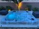 Close-up of a bubbling backyard hot tub, complete with seating and ambient lighting for evening relaxation at 7424 Rainford St, Las Vegas, NV 89148