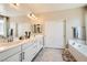 Bright main bathroom features a double sink vanity and a soaking tub with a shower at 7424 Rainford St, Las Vegas, NV 89148