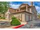 View of condos with garages, red tile roof, and manicured landscaping at 75 N Valle Verde Dr # 211, Henderson, NV 89074