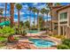 Resort-style pool and spa area surrounded by lush landscaping and palm trees, perfect for relaxation and entertainment at 75 N Valle Verde Dr # 211, Henderson, NV 89074
