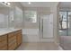 Bright bathroom with double sink vanity, soaking tub, glass shower, and natural light from the windows at 7544 Coral River Dr, Las Vegas, NV 89131