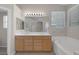Bright bathroom showcases a double sink vanity, large mirror, soaking tub, and natural light from windows at 7544 Coral River Dr, Las Vegas, NV 89131