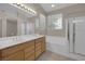 Bright bathroom showcases a double sink vanity, soaking tub, glass shower, and natural light from windows at 7544 Coral River Dr, Las Vegas, NV 89131