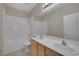Bright bathroom with double sinks, wood cabinets, and a tiled shower-tub combo at 7544 Coral River Dr, Las Vegas, NV 89131