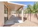 Covered patio space with a concrete pad, desert landscaping, and a block fence for privacy and relaxation at 7544 Coral River Dr, Las Vegas, NV 89131