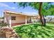 The backyard features a covered patio, artificial grass and mature trees at 8113 Danaides Ct, Las Vegas, NV 89131