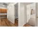 Hallway with wood flooring leads to bathroom, bedroom, and built-in desk with cabinets at 8113 Danaides Ct, Las Vegas, NV 89131