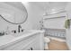 Bright bathroom features a vanity with round mirror and a shower-tub combo with decorative curtain at 823 Spikenard Dr, Henderson, NV 89002