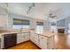 Well-lit kitchen featuring white cabinets, wood floors, and an adjacent living space with a fireplace at 8309 Windrush Ave, Las Vegas, NV 89117