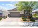 Charming single-story home with a brick driveway, desert landscaping, and a two-car garage at 8351 Vinamala Ave, Las Vegas, NV 89149