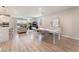 Open-concept living and dining area with wood floors, minimalist furnishings, and recessed lights at 8351 Vinamala Ave, Las Vegas, NV 89149