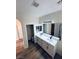 Bathroom boasting dual sinks, stylish cabinets, mirrors, and wood-look flooring for a modern touch at 8616 Willow Cabin St, Las Vegas, NV 89131