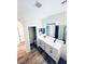 Modern bathroom showcasing double sinks, white cabinetry and wood-look flooring at 8616 Willow Cabin St, Las Vegas, NV 89131