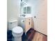 Modern bathroom featuring a toilet, vanity with a sink and cabinets, and stylish wood-look flooring at 8616 Willow Cabin St, Las Vegas, NV 89131