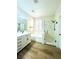 A bathroom featuring wood-look floors, a vanity sink, a bathtub, and a glass shower at 8616 Willow Cabin St, Las Vegas, NV 89131