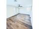 A spacious bedroom featuring wood-look floors, a ceiling fan, and natural light from multiple windows at 8616 Willow Cabin St, Las Vegas, NV 89131
