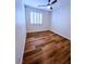 Bright bedroom features wood-look flooring, ceiling fan, and large window with plantation shutters at 8616 Willow Cabin St, Las Vegas, NV 89131