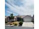 Welcoming home exterior featuring lush landscaping, a tile roof, and a spacious two-car garage at 8616 Willow Cabin St, Las Vegas, NV 89131