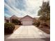 Spacious driveway leading to a two-car garage, surrounded by well-maintained landscaping and mature trees at 8616 Willow Cabin St, Las Vegas, NV 89131