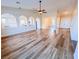 Open-concept living room with new flooring, fan and arched entryways to dining and kitchen at 8616 Willow Cabin St, Las Vegas, NV 89131