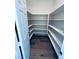 Bright walk-in closet featuring white shelving and wood-look flooring at 8616 Willow Cabin St, Las Vegas, NV 89131