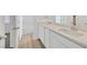 Bathroom featuring double sinks, quartz counters, and wood-look tile flooring at 8852 Flora Run Ave, Las Vegas, NV 89166