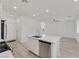 Bright kitchen with a quartz island, stainless steel appliances, and hardwood floors, conveniently near the front door at 8852 Flora Run Ave, Las Vegas, NV 89166