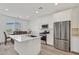 Modern kitchen featuring stainless steel appliances, a quartz island, and an adjacent dining area with a view at 8852 Flora Run Ave, Las Vegas, NV 89166