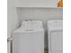 Bright laundry room with modern white appliances and functional shelving at 8852 Flora Run Ave, Las Vegas, NV 89166
