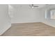 Spacious living room with a ceiling fan, hardwood floors, and bright natural light from the windows at 8852 Flora Run Ave, Las Vegas, NV 89166