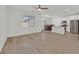 Open-concept living room with hardwood floors leading to a well-lit kitchen and dining area with stainless steel appliances at 8852 Flora Run Ave, Las Vegas, NV 89166