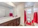 Bright bathroom featuring wood flooring, a red accent towel, and a modern vanity at 9114 Riverlands Ranch St, Las Vegas, NV 89139