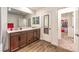 Beautiful bathroom boasting a double vanity, wood-look flooring, and walk-in closet access at 9114 Riverlands Ranch St, Las Vegas, NV 89139