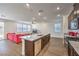 Well-lit open floor plan featuring a kitchen with an island and stainless appliances, leading into a living room area at 9114 Riverlands Ranch St, Las Vegas, NV 89139