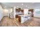 Open-concept kitchen features stainless appliances, a center island with barstool seating, and wood-style flooring at 9114 Riverlands Ranch St, Las Vegas, NV 89139