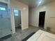 Bright bathroom featuring a tiled glass-enclosed shower, double sinks and tile flooring at 933 Kimbark Ave, Las Vegas, NV 89148