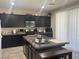 Well-lit kitchen boasts modern black cabinets, a practical island, and granite countertops at 933 Kimbark Ave, Las Vegas, NV 89148
