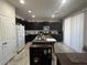 Bright kitchen featuring dark cabinets, granite counters, and a center island at 933 Kimbark Ave, Las Vegas, NV 89148