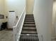 Staircase to the 2nd floor with neutral carpet and a white banister at 933 Kimbark Ave, Las Vegas, NV 89148