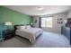 A bedroom with gray carpet, a green accent wall, and modern furniture at 9807 Panther Hollow St, Las Vegas, NV 89141