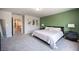 Bright bedroom featuring a king-sized bed, a green accent wall, and modern bedside tables and lamps at 9807 Panther Hollow St, Las Vegas, NV 89141