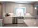 Bright kitchen with stainless steel appliances and white cabinets, including a stainless steel farmhouse sink at 9807 Panther Hollow St, Las Vegas, NV 89141