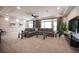 Spacious living room with large windows, a plush gray sectional sofa, and modern decor at 9807 Panther Hollow St, Las Vegas, NV 89141