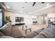 Open-concept living area featuring a gray sectional, large TV, and adjacent dining space at 9807 Panther Hollow St, Las Vegas, NV 89141