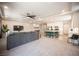 Open-concept living room with a modern kitchen, large island, and comfortable gray sofa at 9807 Panther Hollow St, Las Vegas, NV 89141
